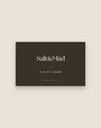 Salt & Mūd E-Gift Card - dark brown card with the Salt & Mūd wordmark on a cream background
