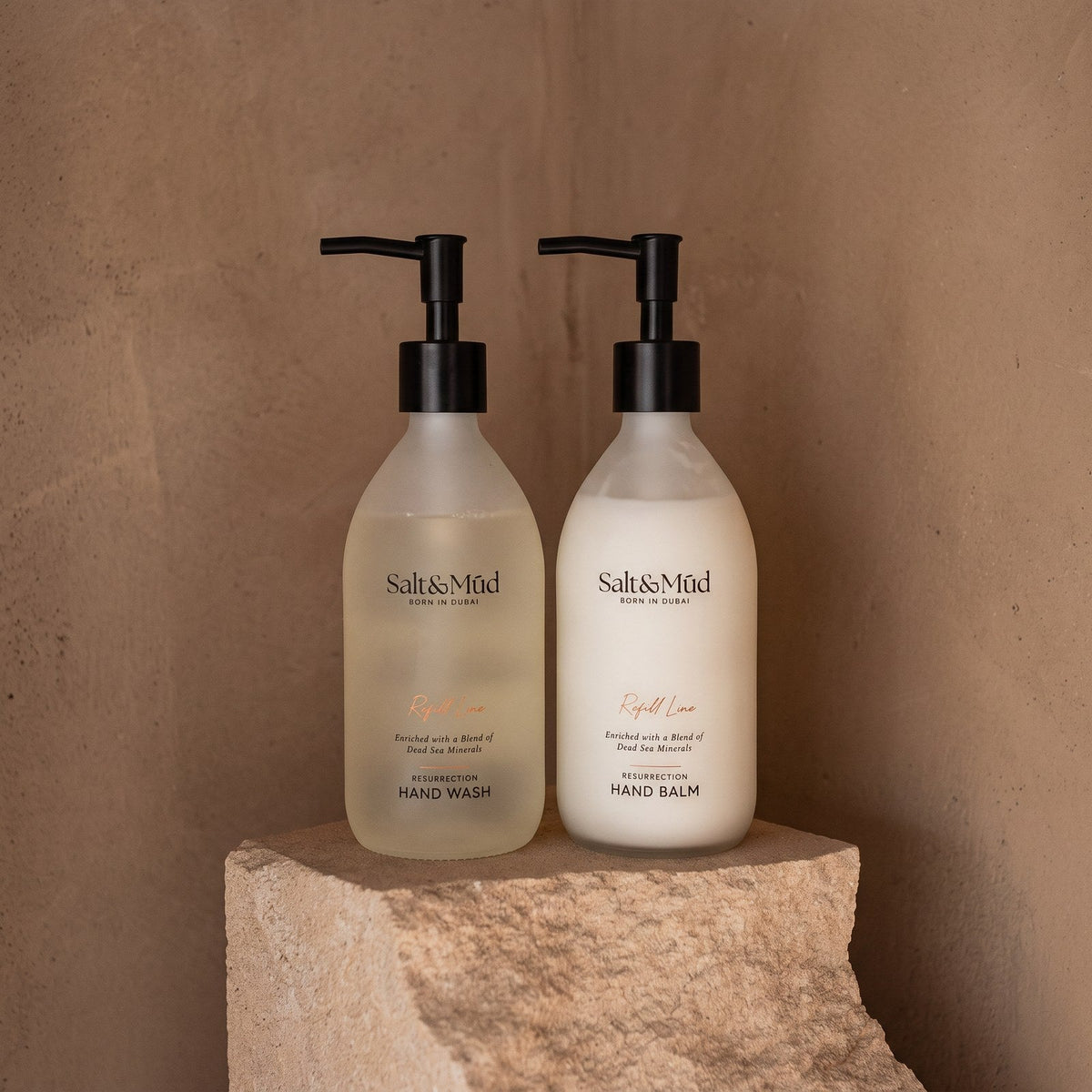 Salt & Mūd Refill Line hand wash and hand balm in frosted glass on stone