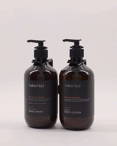 Hotel Dispensers vs Mini Toiletries: amber refillable pump bottles with black labels, one hand wash and one body lotion
